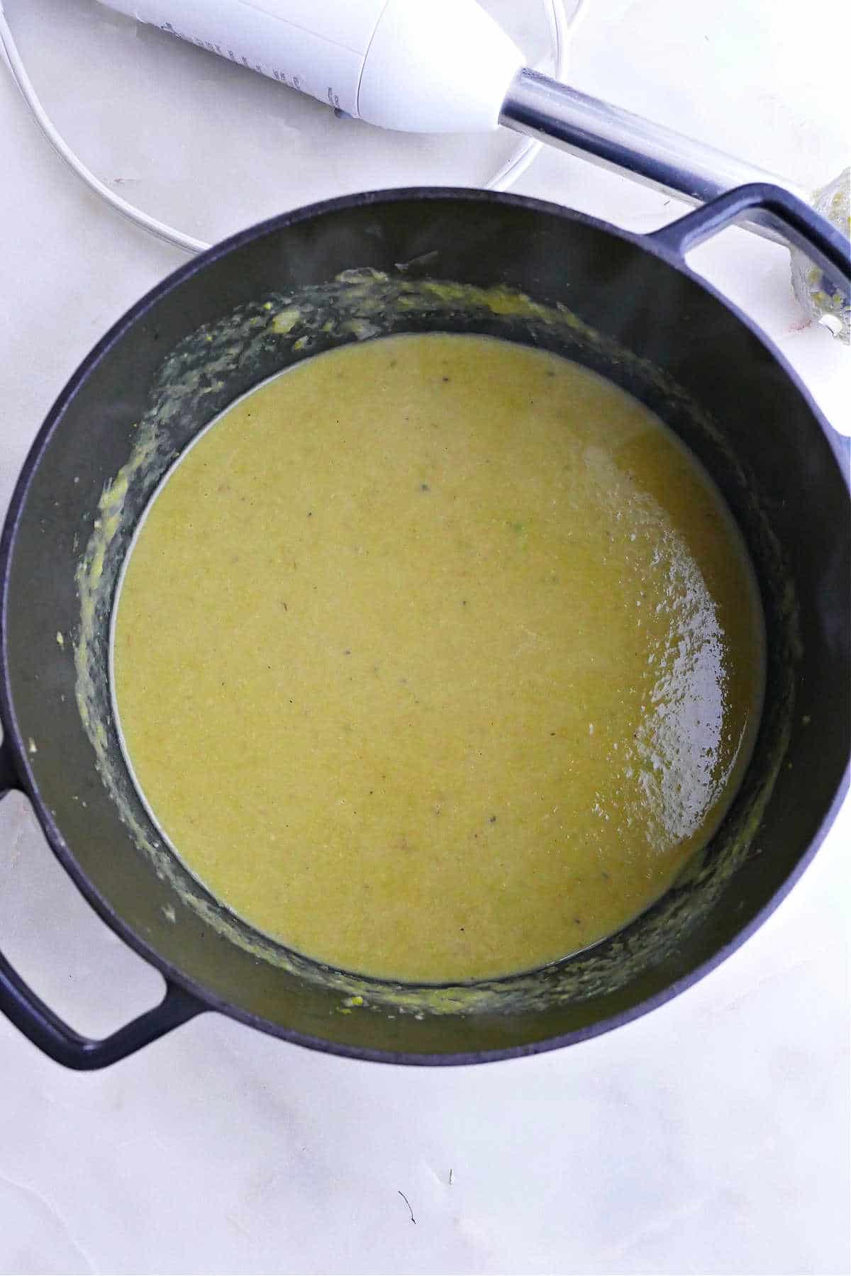 blended vegan cream of asparagus soup in a soup pot on a counter
