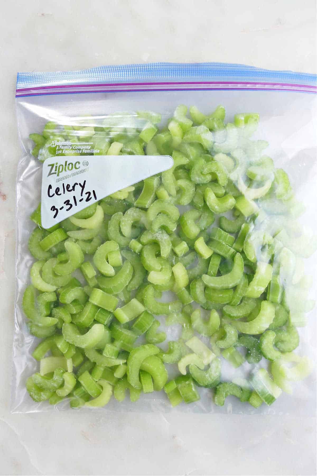 frozen celery in a sealed plastic bag with a date label