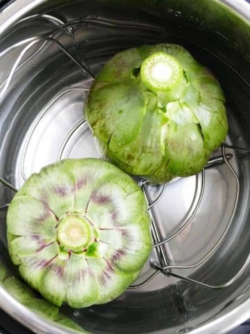 square image of upside down artichokes in an instant pot