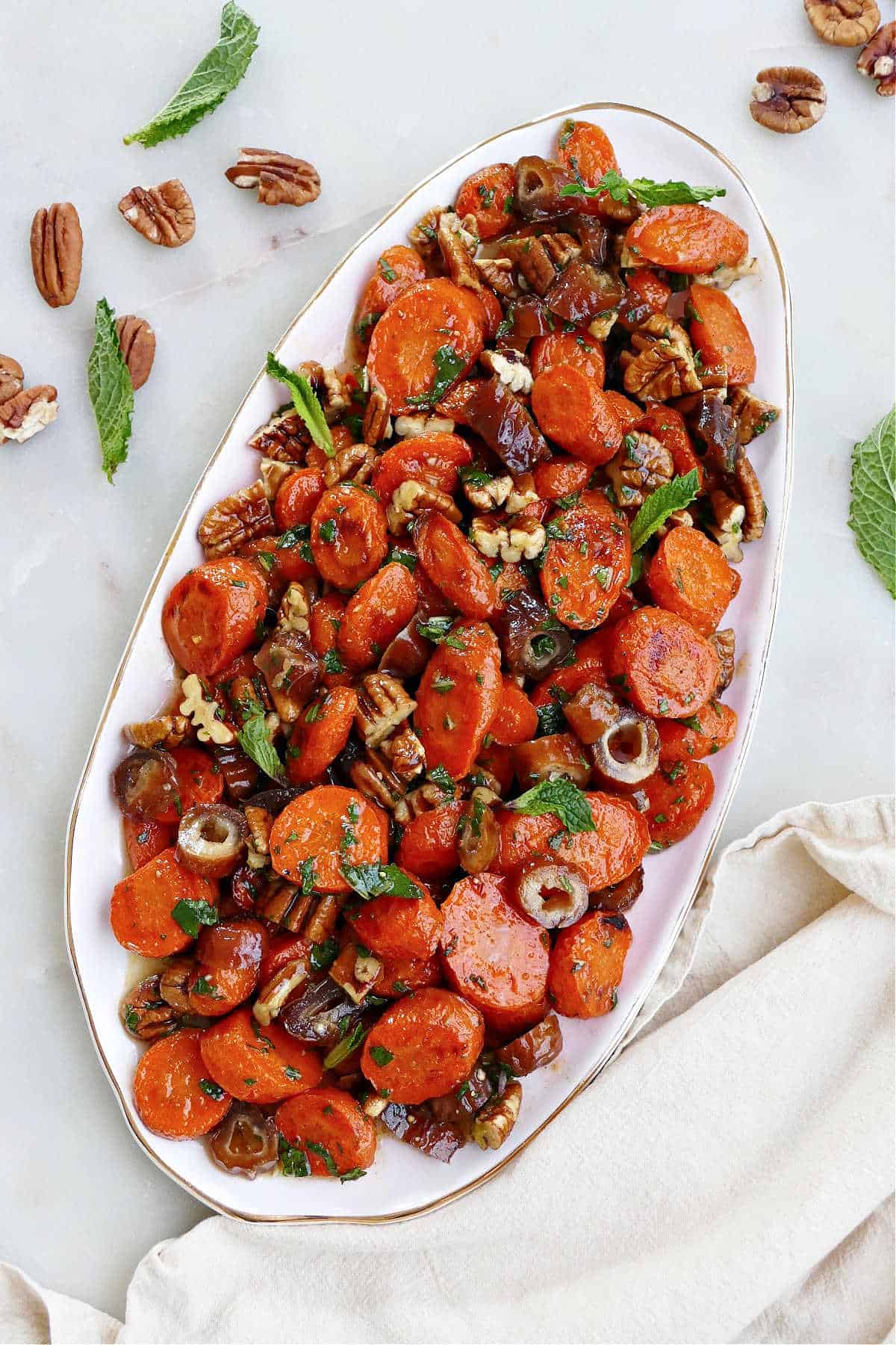 spiced carrots and dates on an oval serving dish on a counter