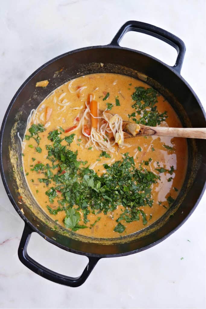 vermicelli soup topped with fresh mint and basil in a large pot