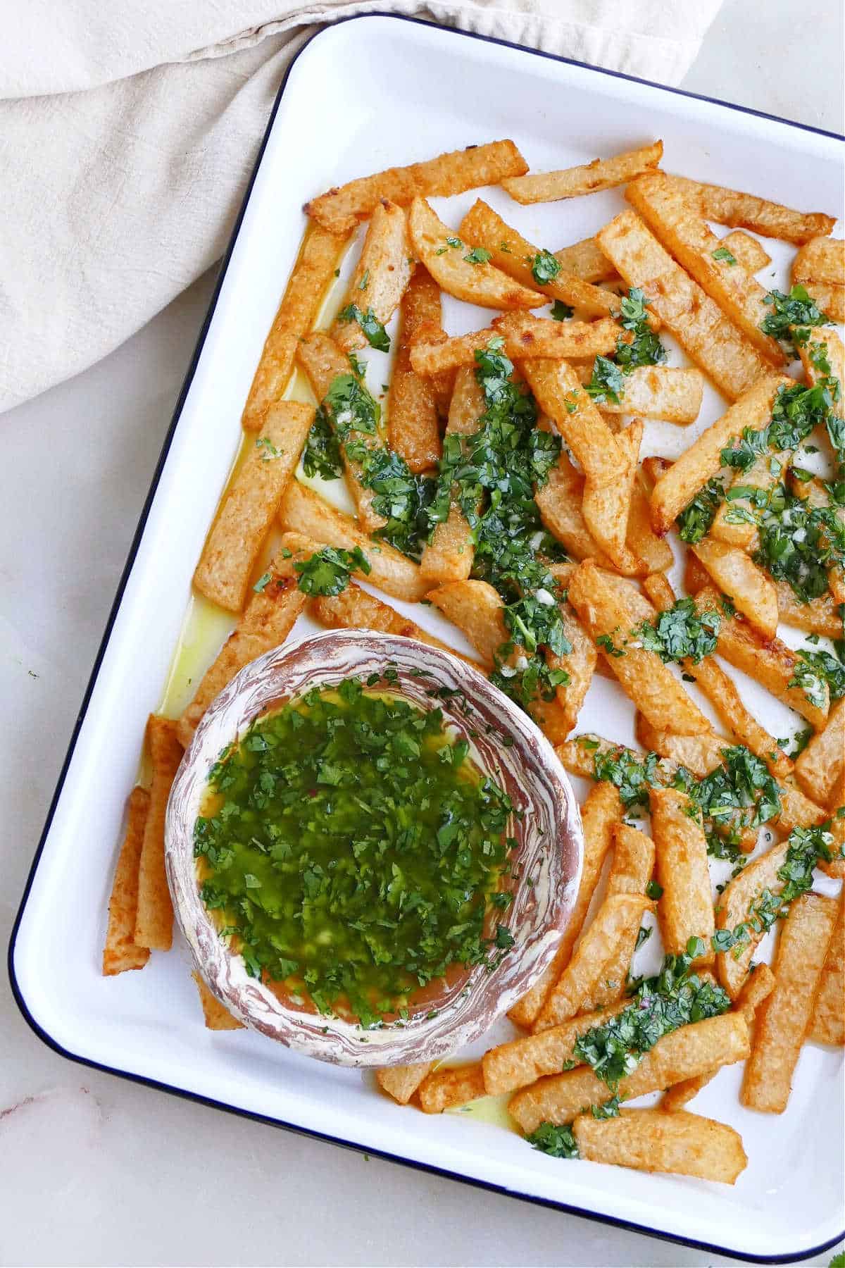 close image of cilantro lime dressing surrounded by jicama fries on a platter