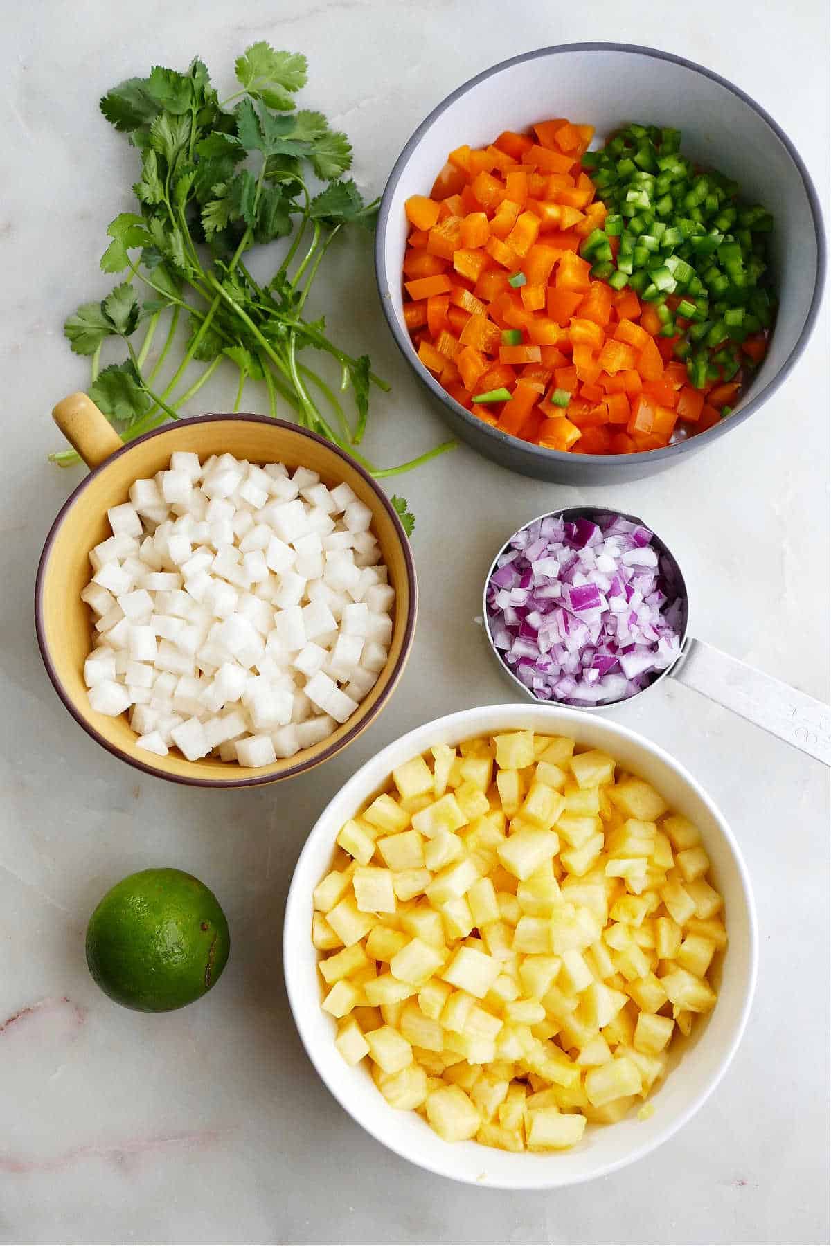 ingredients for pineapple jicama salsa spread out next to each other on a counter