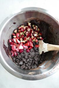 batter for rhubarb brownies in a bowl with rhubarb, berries, and chocolate mixed in