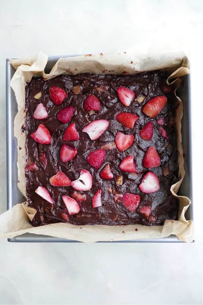 strawberry rhubarb brownies in a square pan before baking