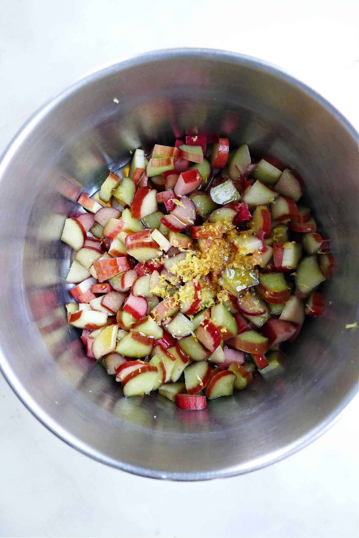 diced rhubarb, maple syrup, and lemon zest cooking in a saucepan