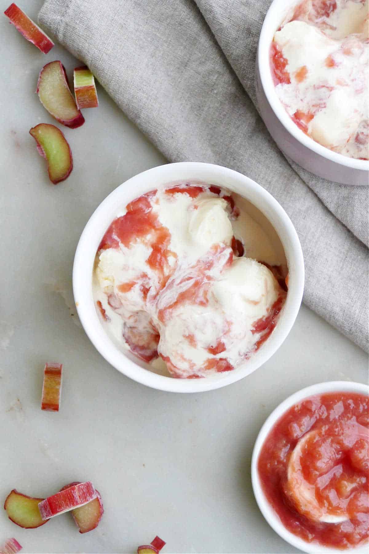 small bowl of vanilla ice cream with rhubarb sauce on a counter