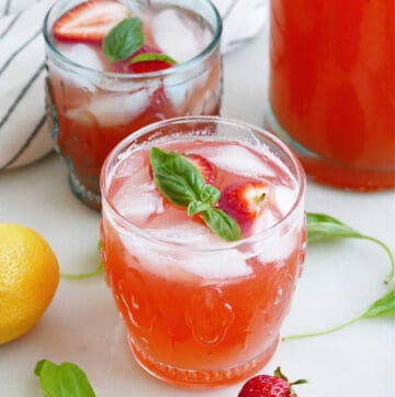 strawberry basil lemonade in front of another glass and pitcher on a counter