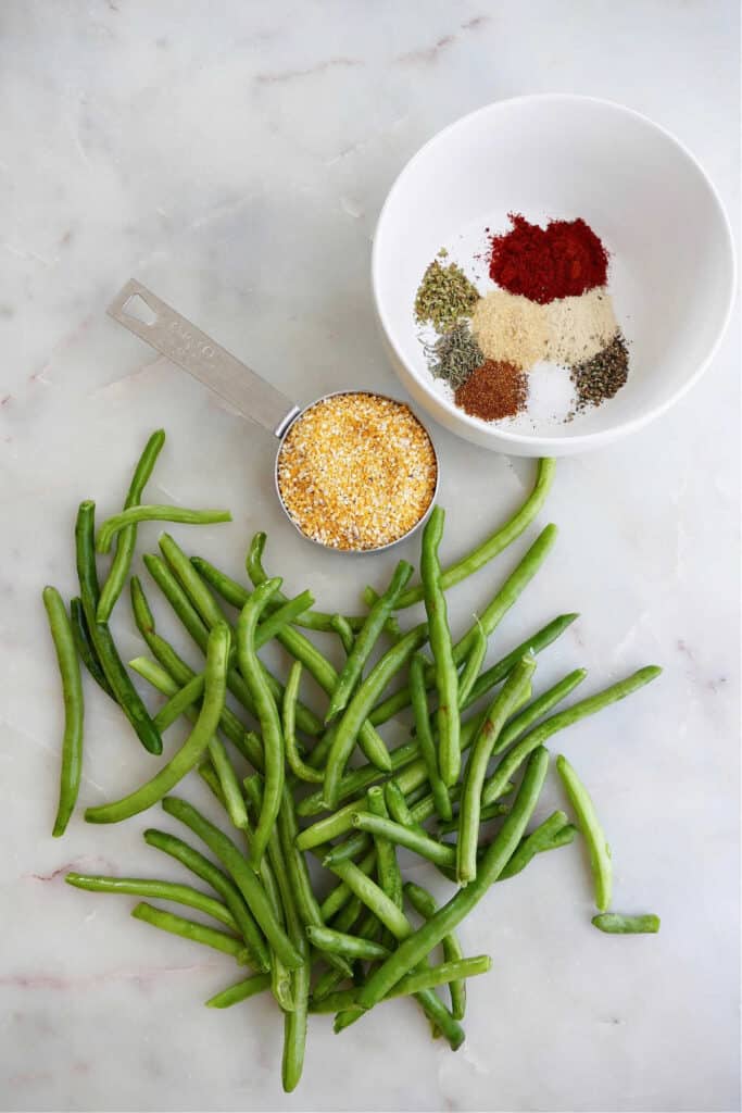 green beans, grits, and spices in a bowl next to each other on a counter