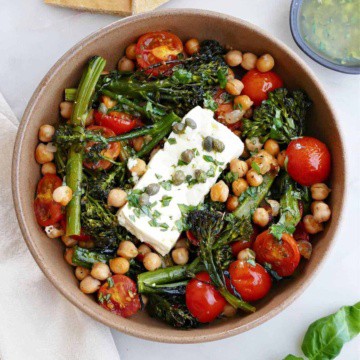 baked feta with vegetables and chickpeas in a serving bowl on a counter