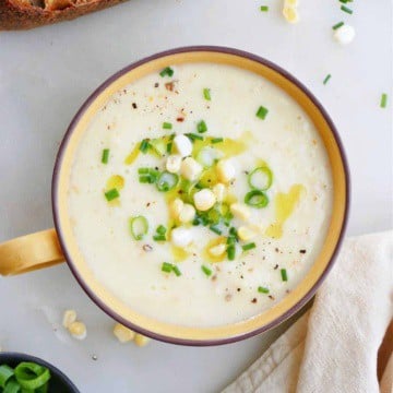 corn gazpacho in a serving bowl topped with corn kernels and scallions