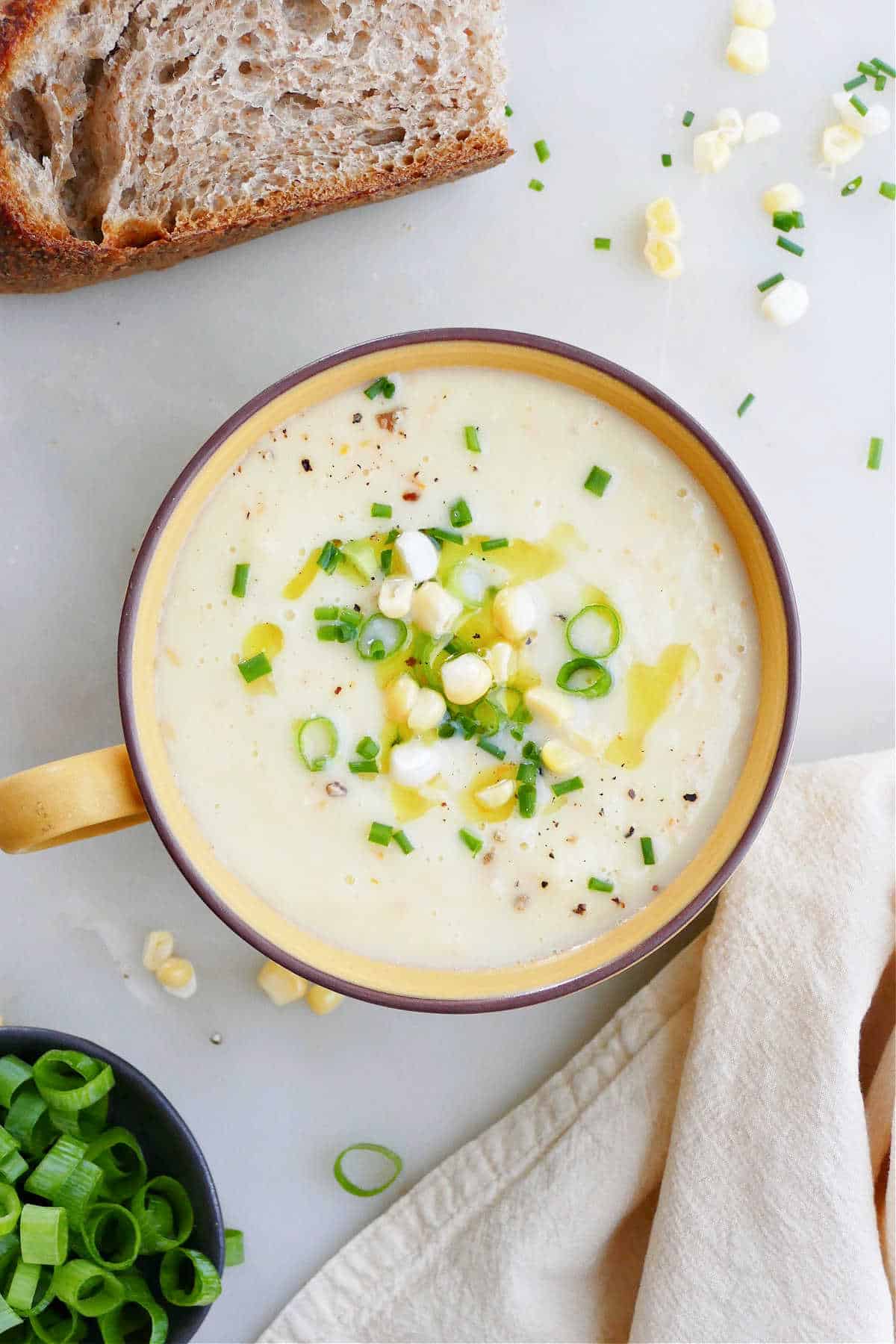 corn gazpacho in a serving bowl topped with corn kernels and scallions