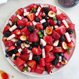 Red, white, and blue fruit salad on a large serving dish on a counter.