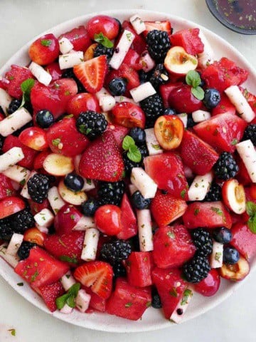 red, white, and blue fruit salad on a large serving dish on a counter