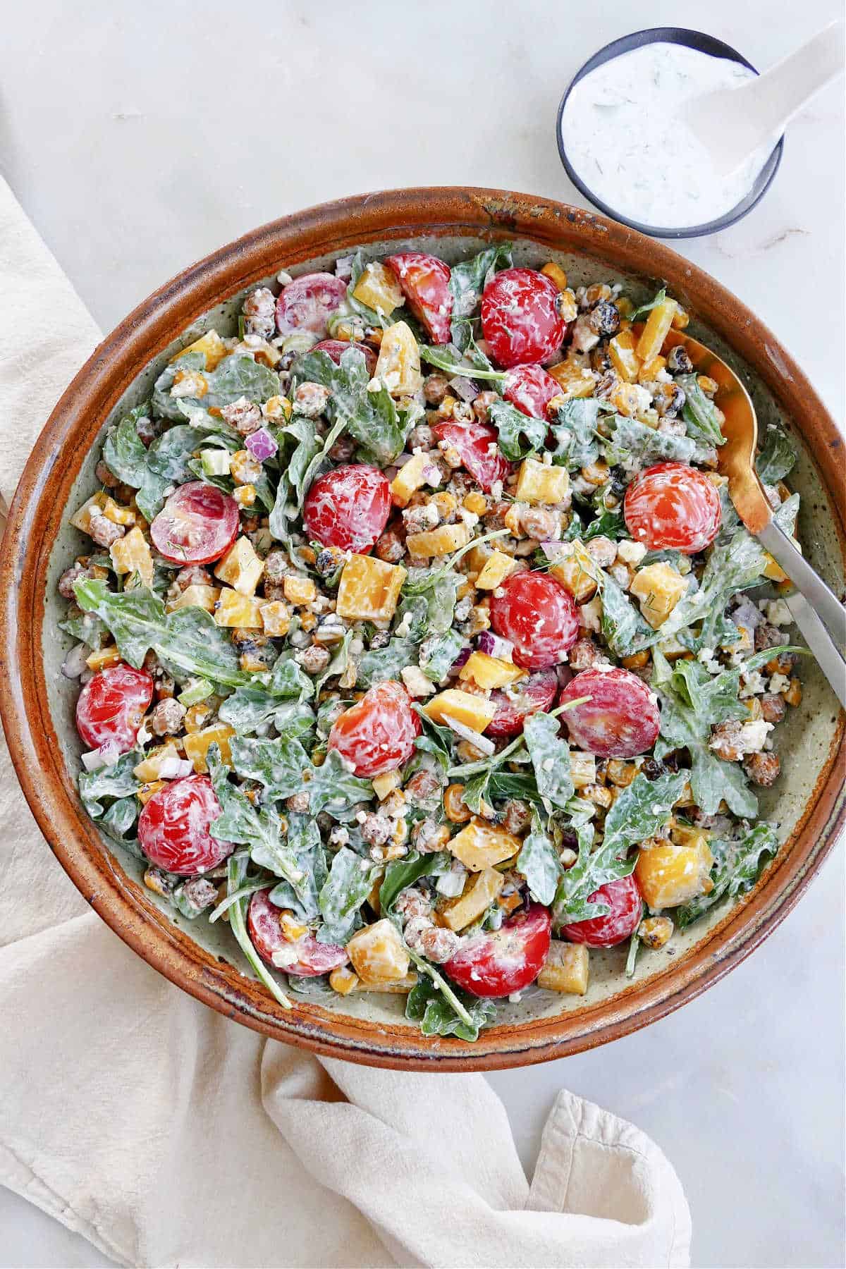 roasted chickpea salad with dressing in a serving bowl on top of a counter