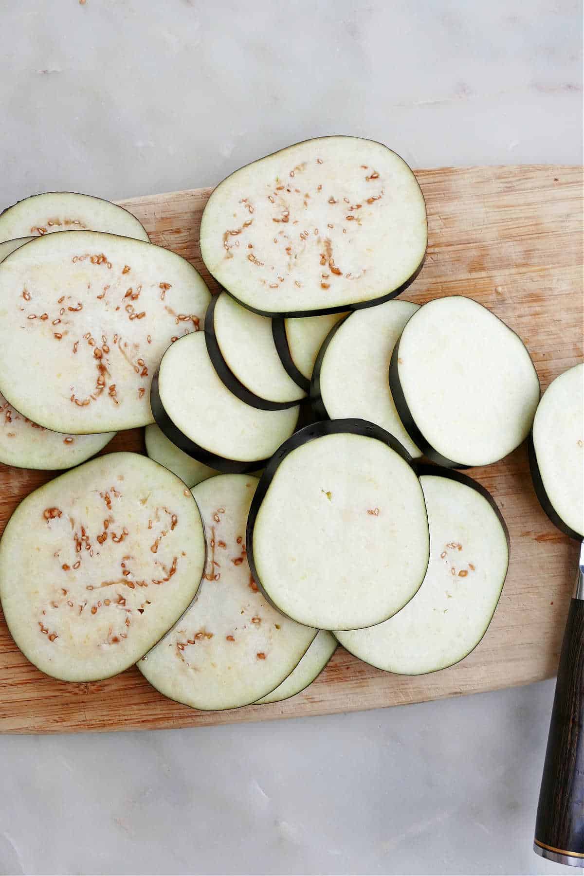 sliced eggplant rounds on top of each other on a cutting board