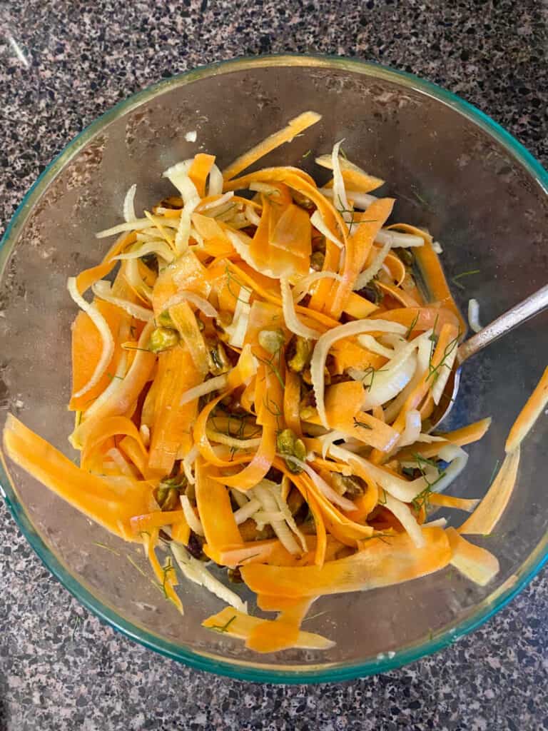 shaved carrot and fennel salad with pistachios in a glass bowl