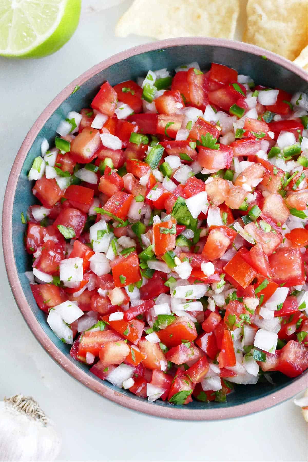 garden salsa with jalapeno, onion, and cilantro in a serving bowl next to chips