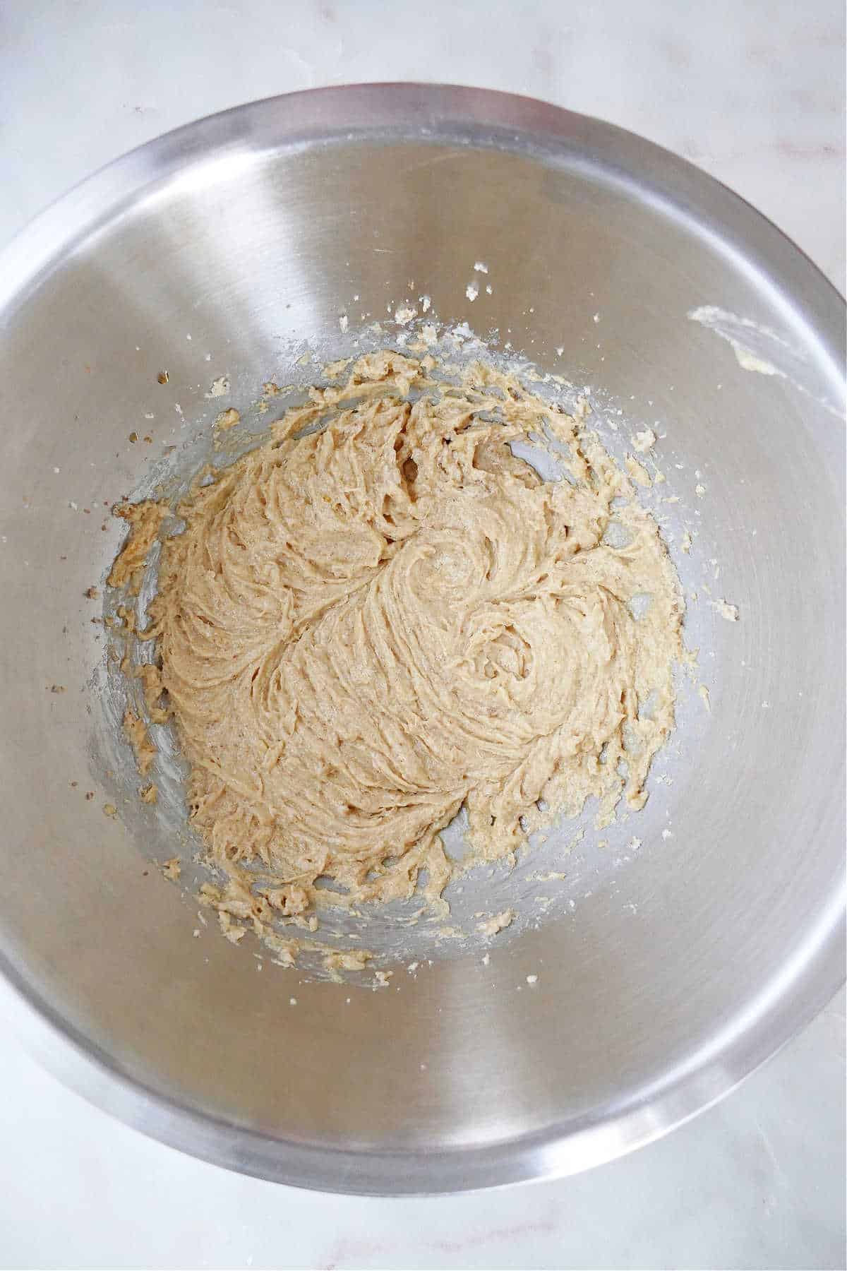 creamed sugar, butter, and eggs in a large mixing bowl on a counter