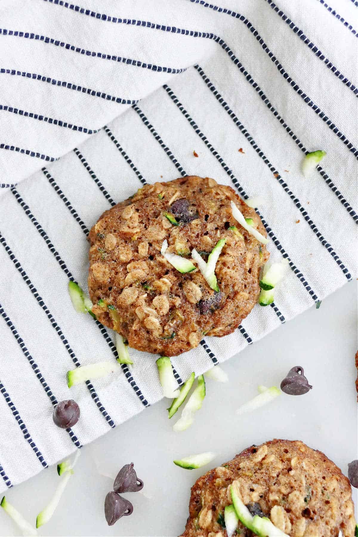 zucchini chocolate chip cookie on a striped dish towel on a counter