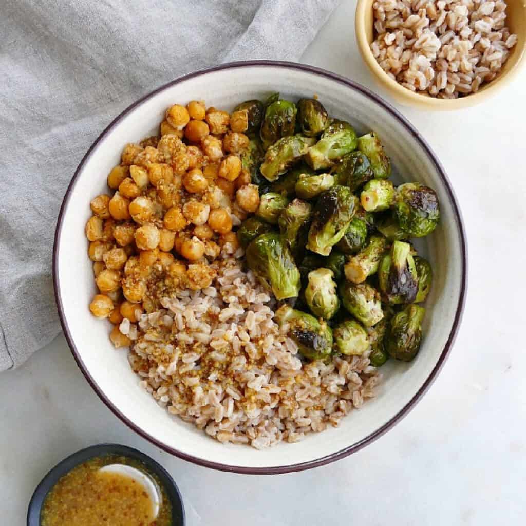 brussels sprouts, chickpeas, and farro in a serving bowl on a counter