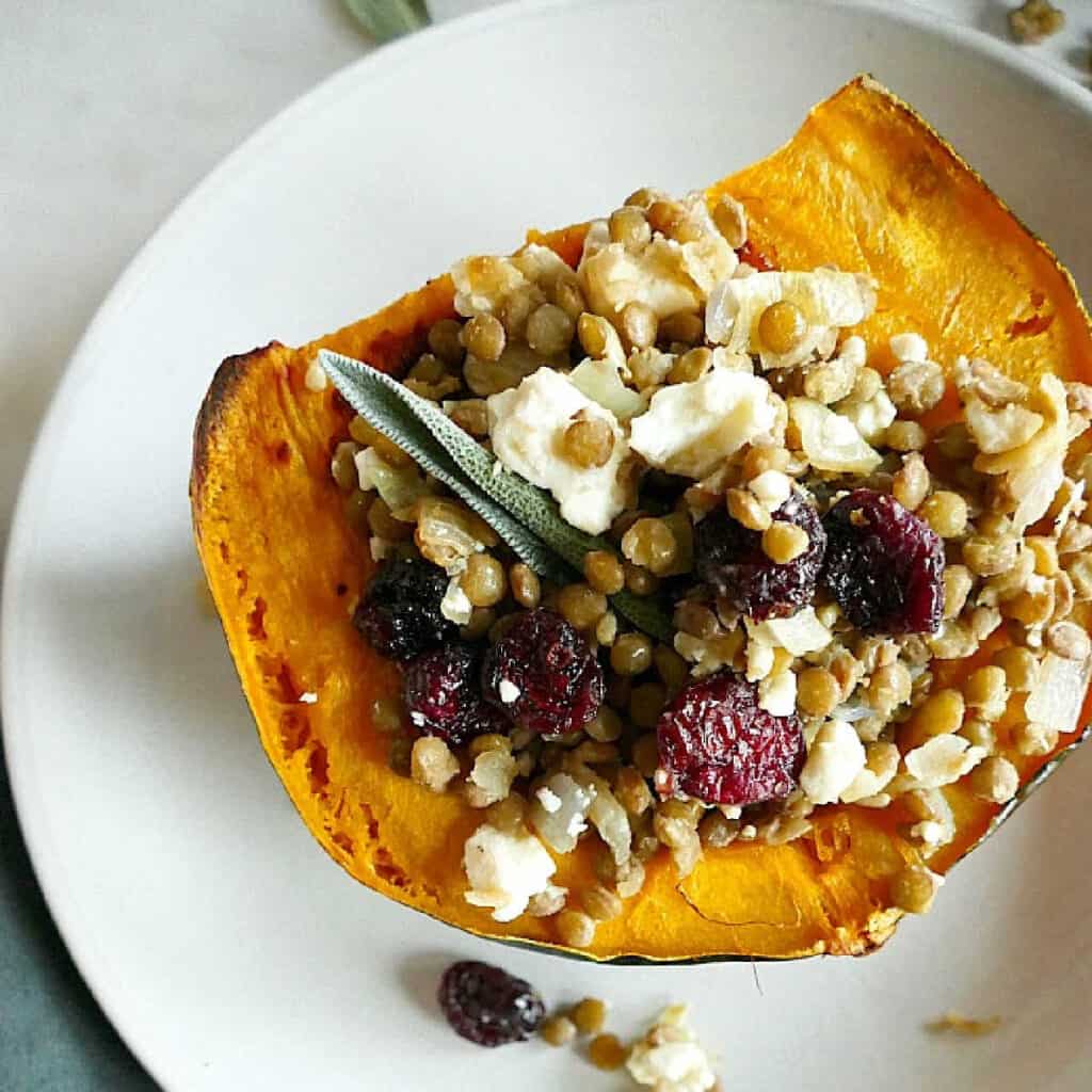 lentil stuffed acorn squash with sage on a serving dish