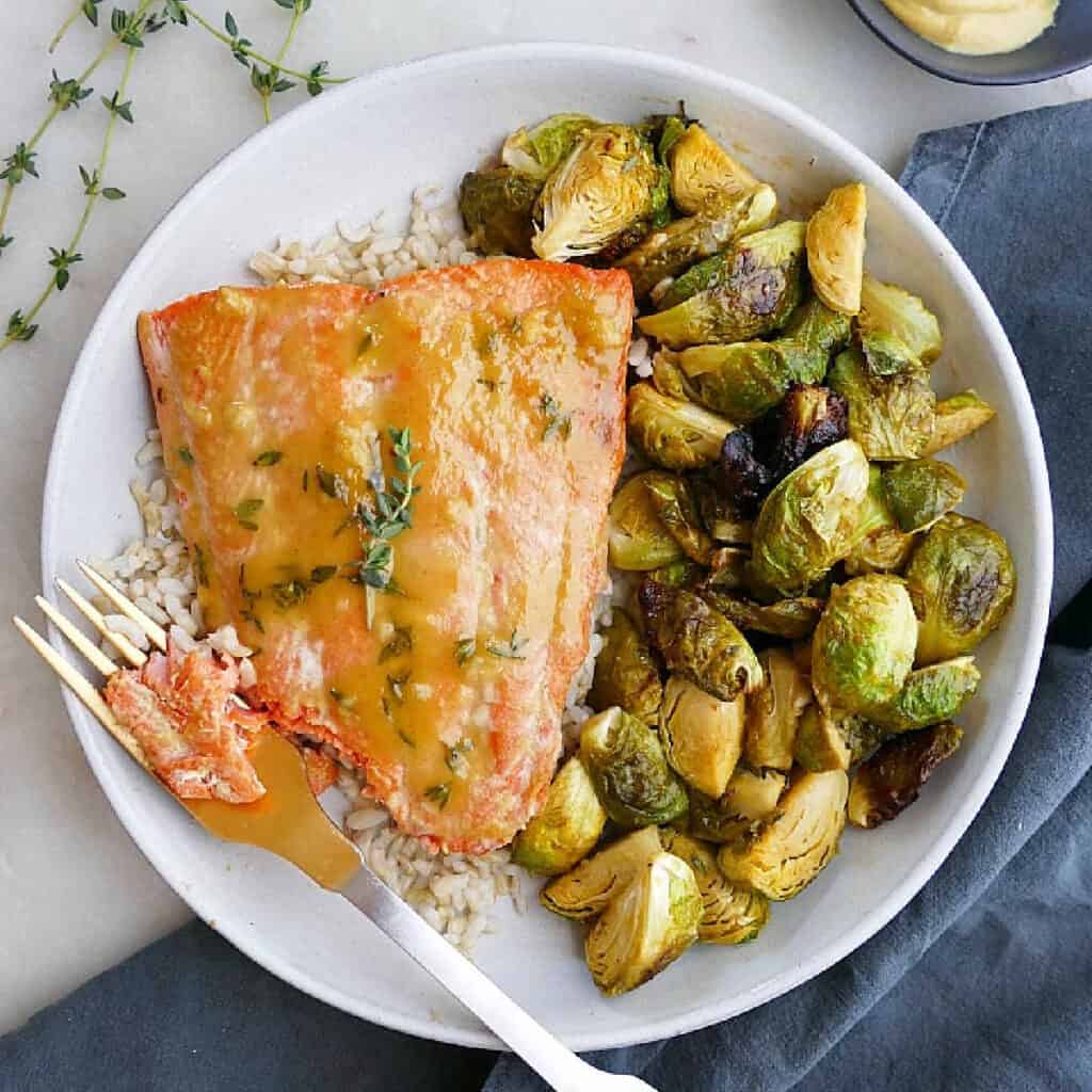 maple mustard salmon and Brussels sprouts on a plate with a fork