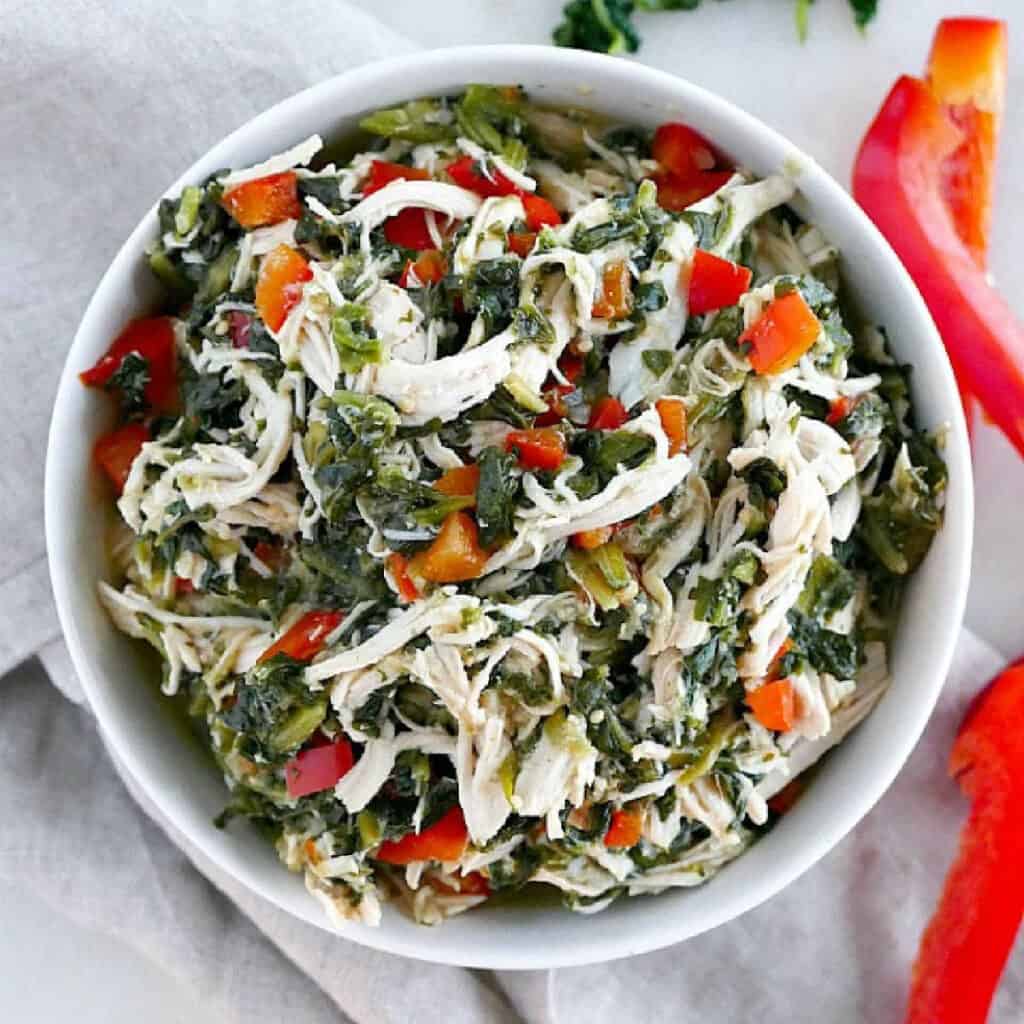 Mexican shredded chicken with veggies in a serving bowl on a counter