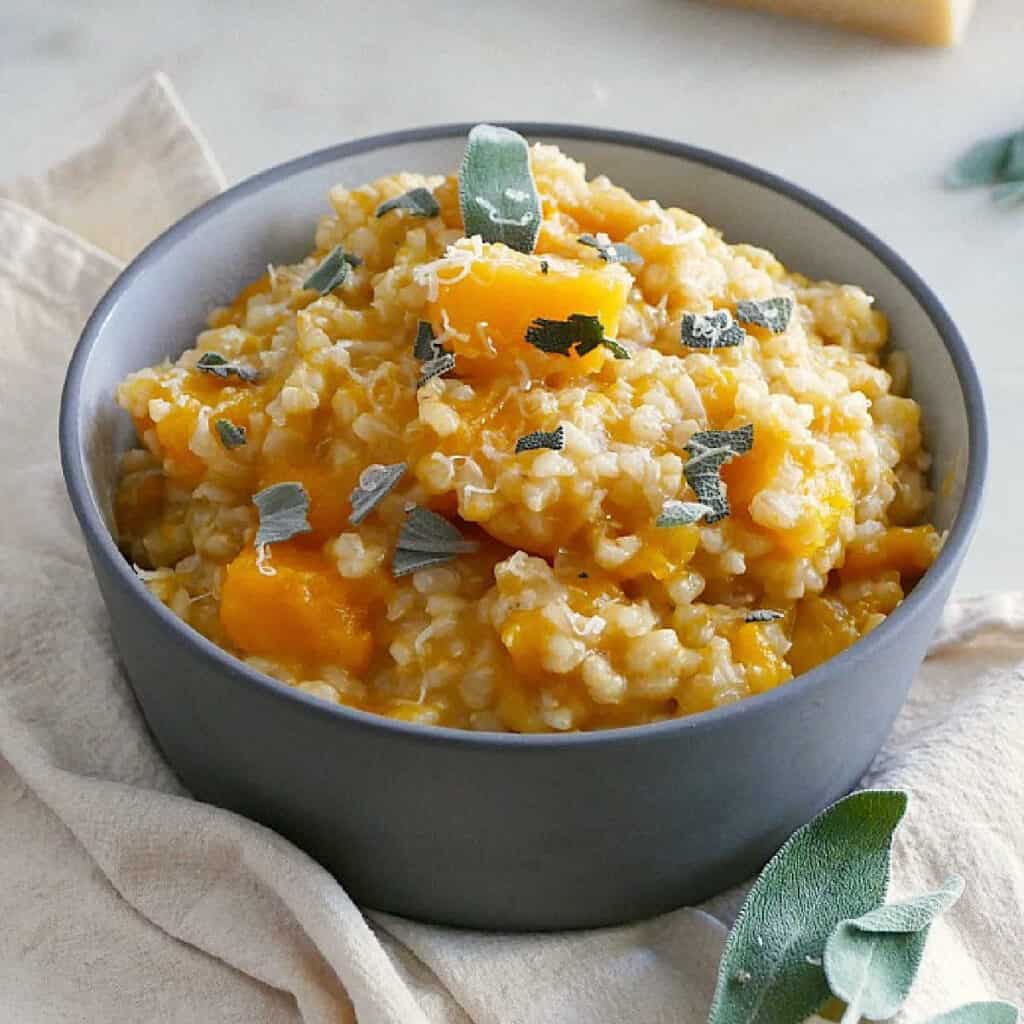 slow cooker butternut squash risotto in a serving dish topped with sage