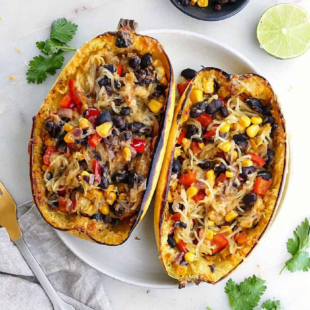 spaghetti squash burrito bowls in spaghetti squash halves on a serving plate