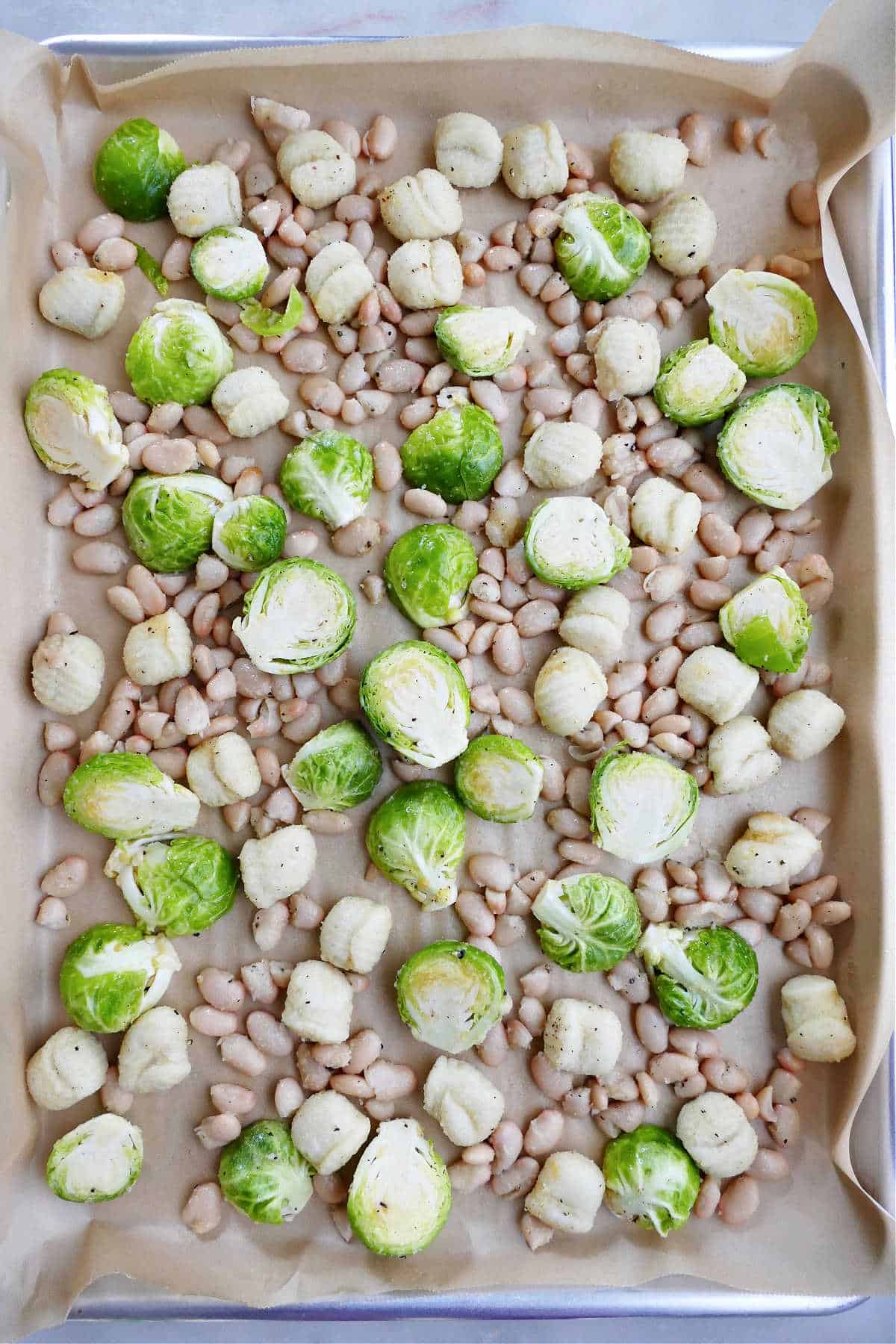 lined sheet pan with Brussels sprouts, white beans, and gnocchi spread out on top