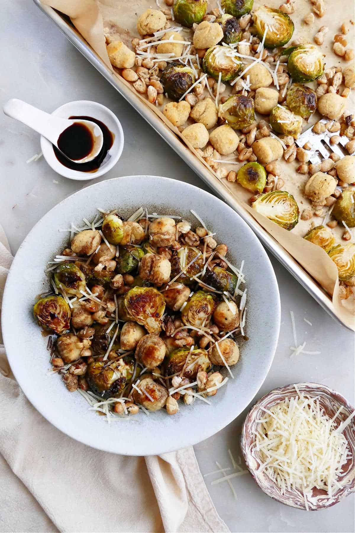 sheet pan gnocchi and Brussels sprouts in a serving bowl next to baking sheet
