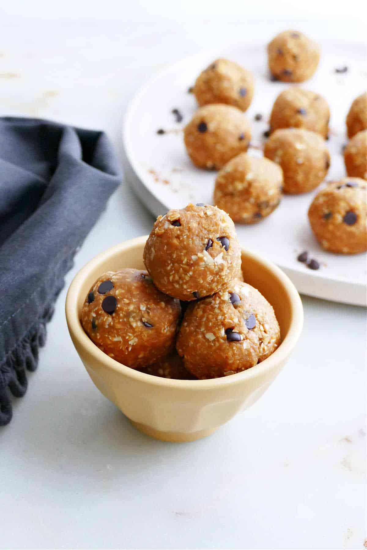 three pumpkin peanut butter balls on top of each other in a small bowl 