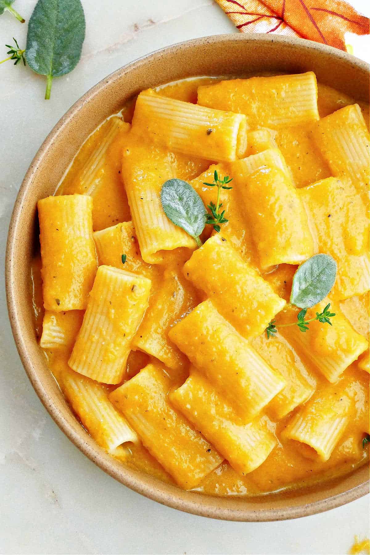 slow cooker butternut squash mac and cheese over rigatoni in a serving bowl