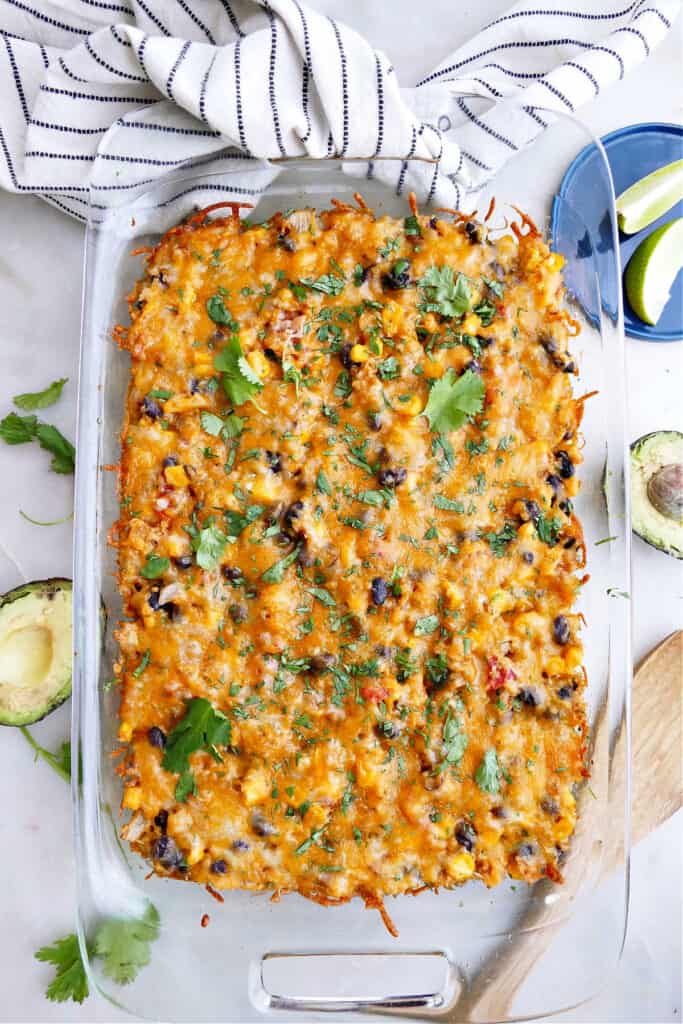 vegetarian quinoa Mexican casserole in a baking dish surrounded by toppings