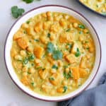 butternut squash and chickpea curry in a serving bowl topped with cilantro leaves