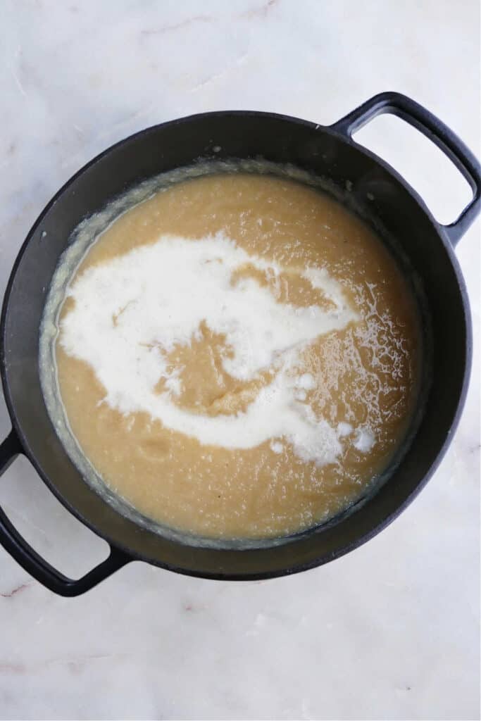 blended celeriac and parsnip soup with milk poured into it in a soup pot