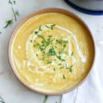 leek, potato, and fennel soup in a bowl with chives and heavy cream