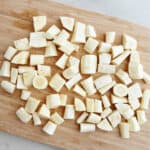 diced parsnips cut into bite-sized pieces on a bamboo cutting board