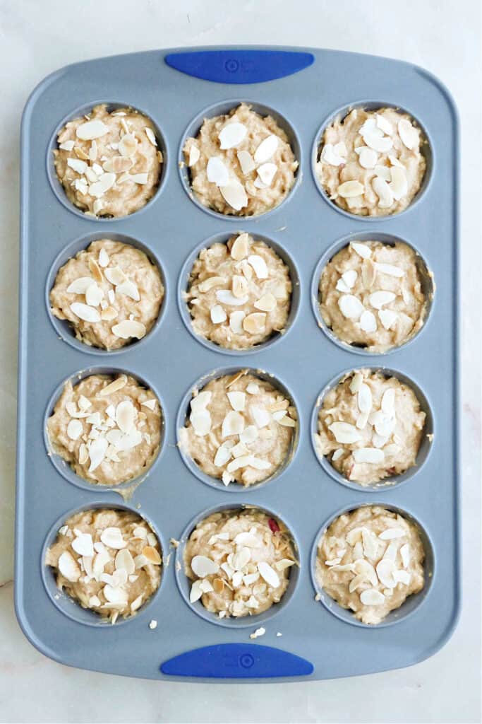 parsnip muffins topped with toasted almonds in a silicone muffin pan before baking