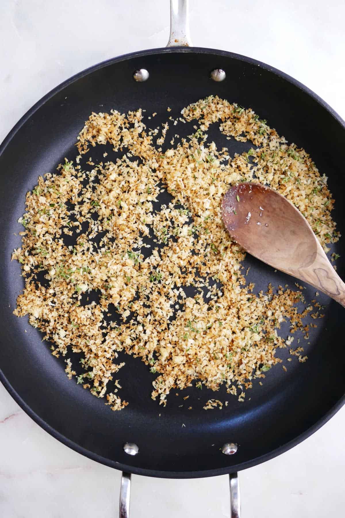 panko breadcrumbs cooking in a skillet with olive oil, garlic, and thyme