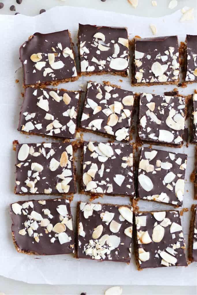 12 almond butter bars sliced into squares and topped with almonds on a counter