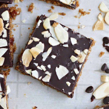 an almond butter bar topped with chocolate and sliced almonds on a counter