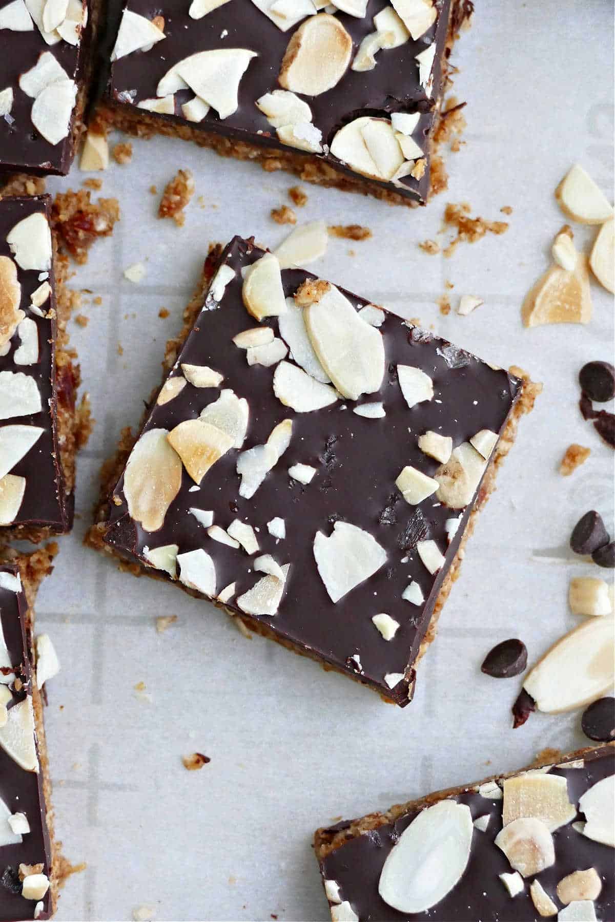 an almond butter bar topped with chocolate and sliced almonds on a counter