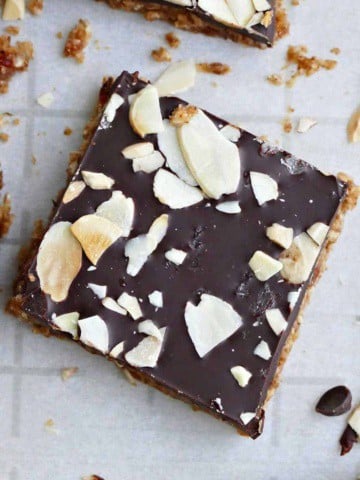 an almond butter bar topped with chocolate and sliced almonds on a counter