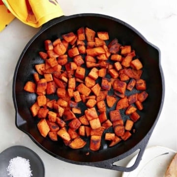 pan fried sweet potatoes in a cast iron skillet on a counter