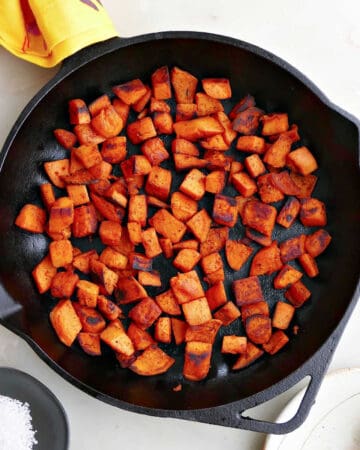 pan fried sweet potatoes in a cast iron skillet on a counter