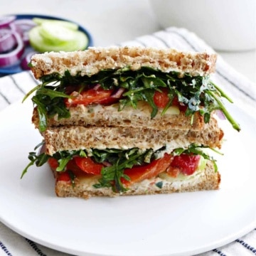 veggie cheese sandwich sliced in half and stacked on a plate