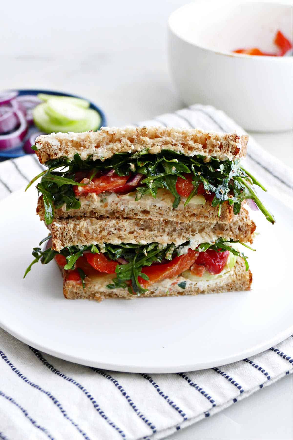 veggie cheese sandwich sliced in half and stacked on a plate