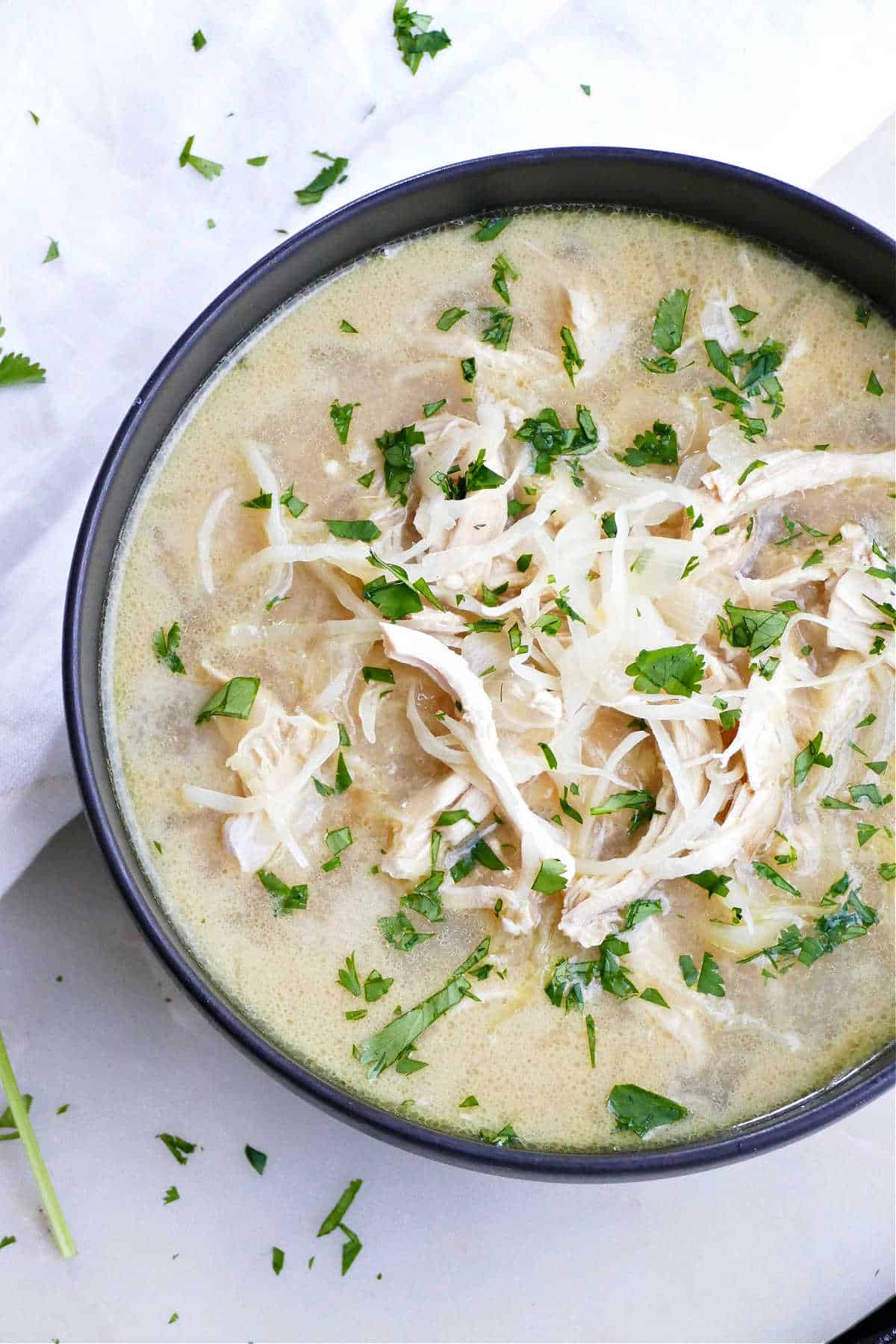 cabbage chicken soup with cilantro and coconut milk next to a napkin